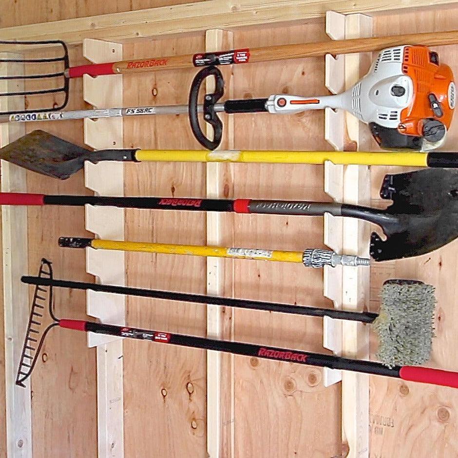 Stud-mounted garden tool organizer rack holding long-handled tools